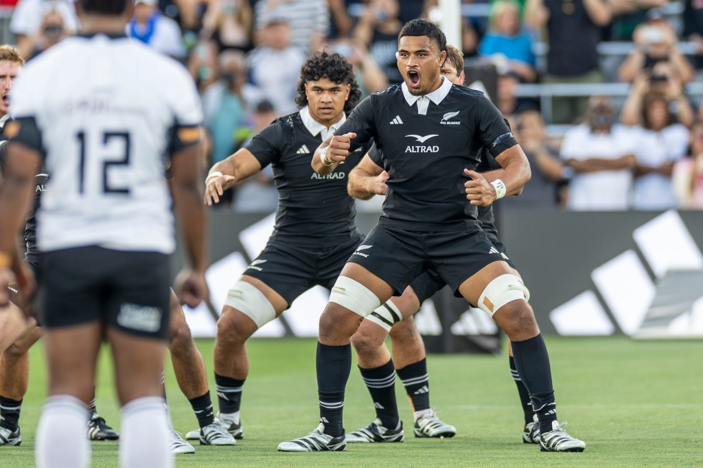 A group of rugby players performing a traditional haka dance, showcasing their strength and unity before a match.